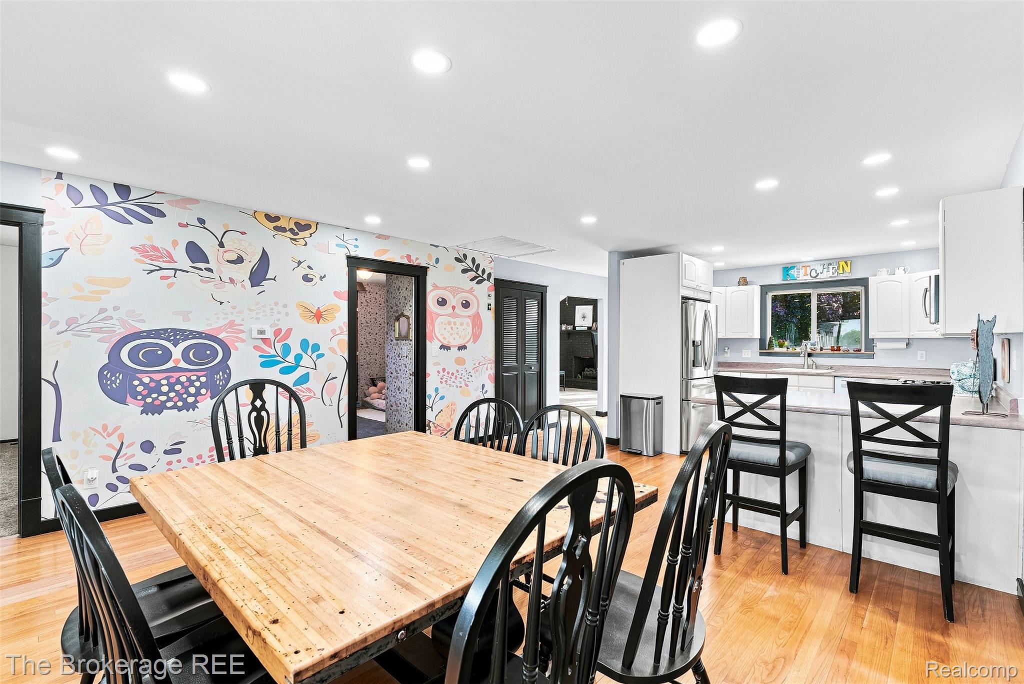 4443 North Gale Road Davison, MI 48423 - Photo 16 of 36 Hardwood flooring, recessed ceiling lighting, wall-mounted cabinetry, stainless steel refrigerator, and a stainless steel range hood