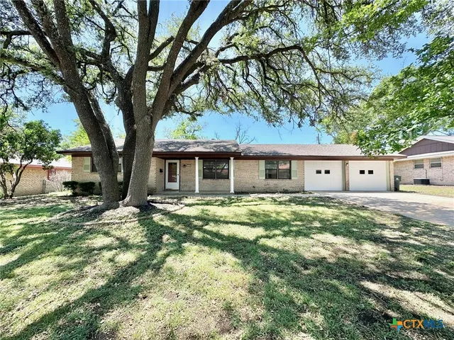 a front view of house with yard and trees
