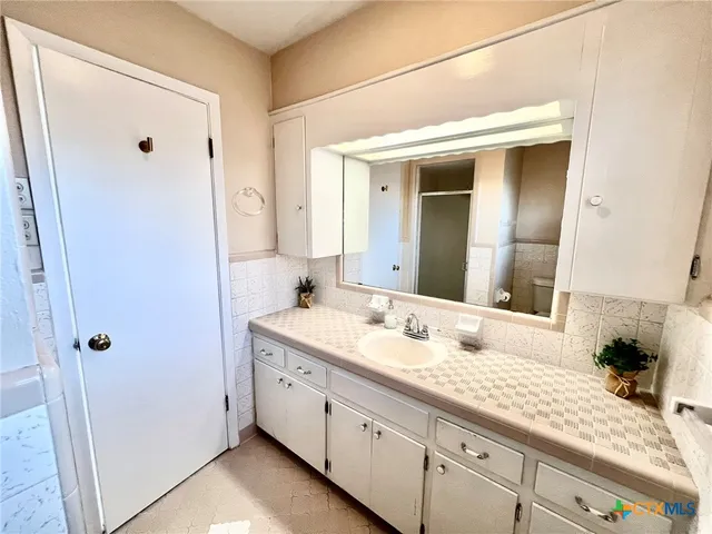 a bathroom with a granite countertop sink mirror and double