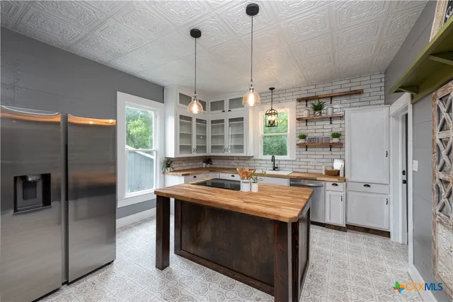 a kitchen with a stove a refrigerator a sink a dining table and chairs