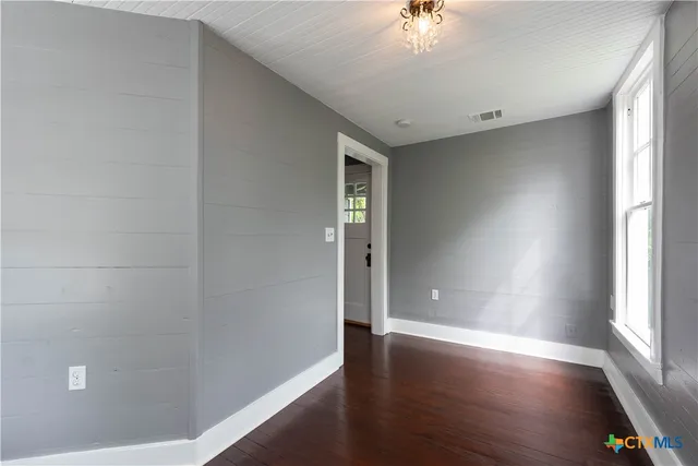 wooden floor in an empty room with a window