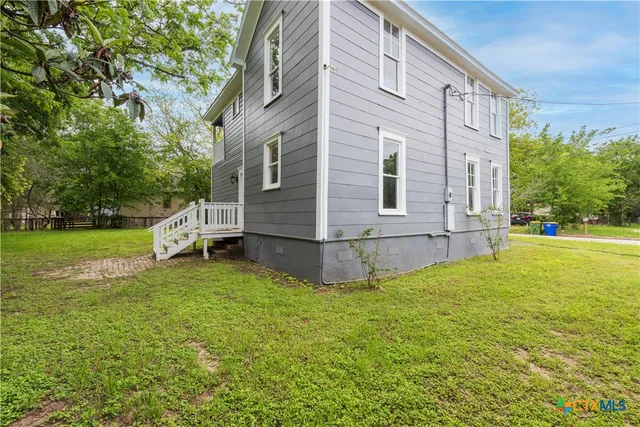 a view of a house with a yard and sitting area