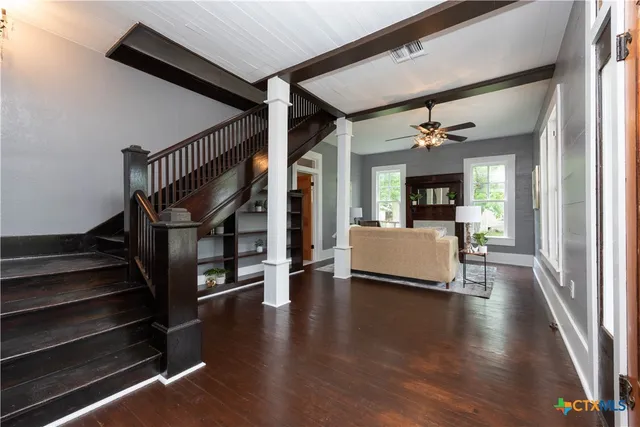 a view of a livingroom with wooden floor and a staircase