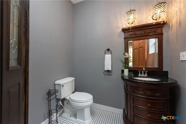 a bathroom with a toilet a sink and mirror
