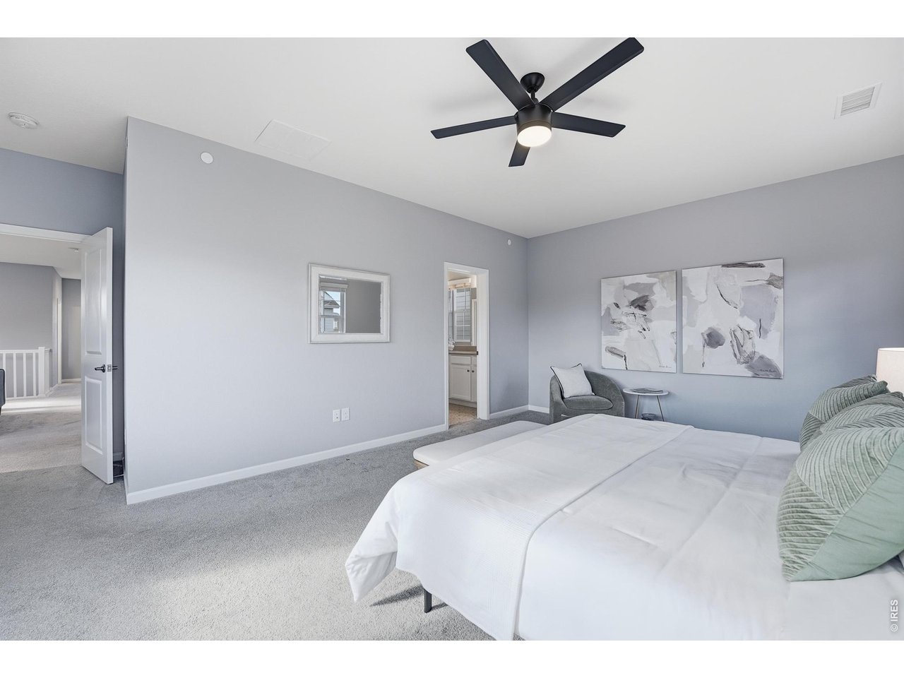 10094 Flower Street Broomfield, CO 80021 - Photo 22 of 40 a bedroom with a large bed and a chandelier