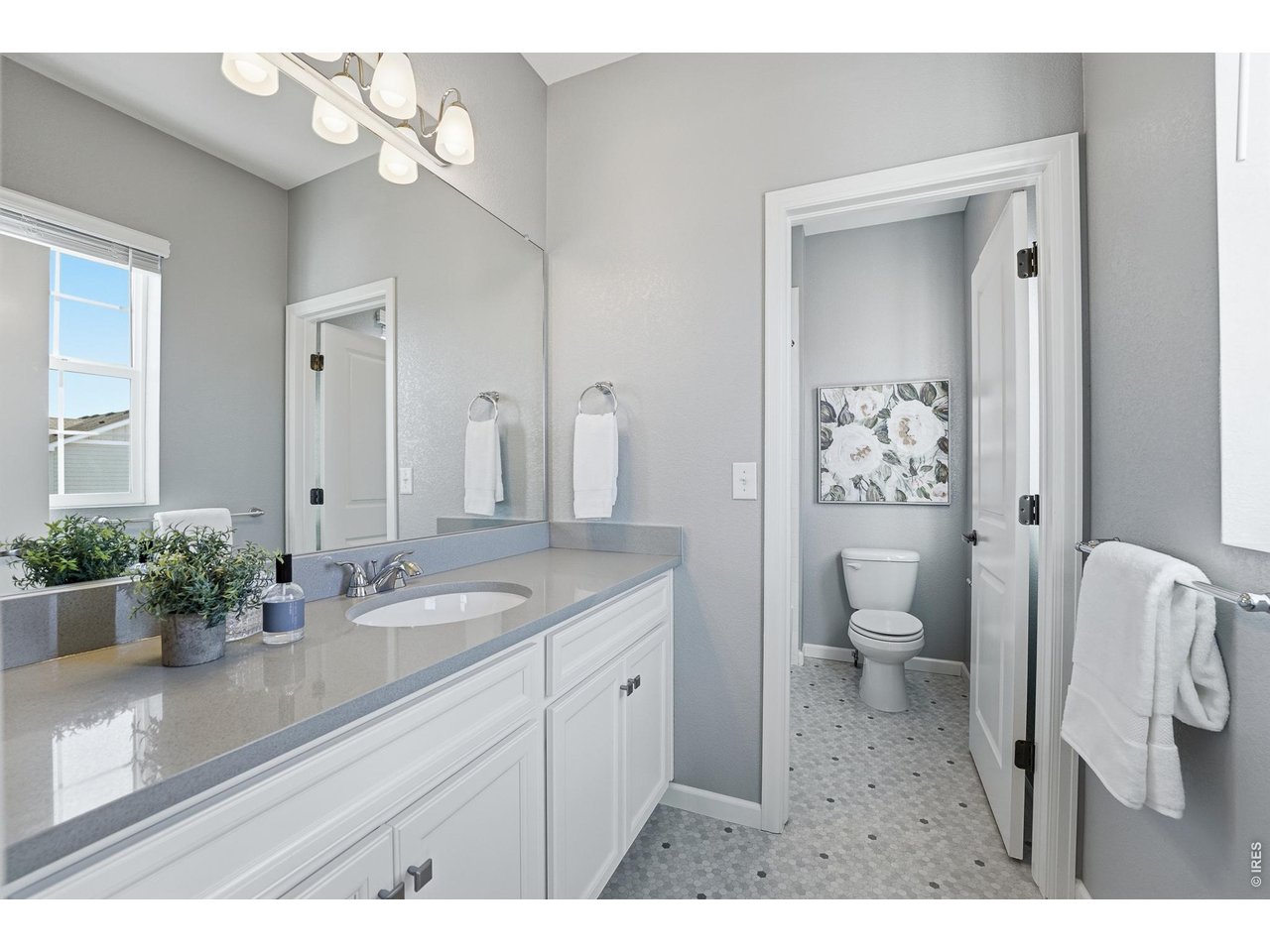 10094 Flower Street Broomfield, CO 80021 - Photo 28 of 40 a spacious bathroom with a granite countertop sink a toilet and a mirror