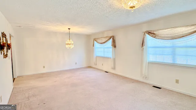 an empty room with windows and closet