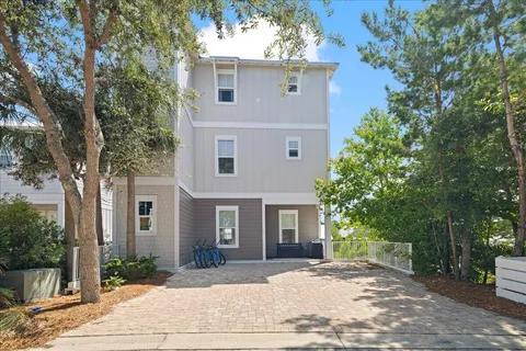 a front view of a house with yard and tree s