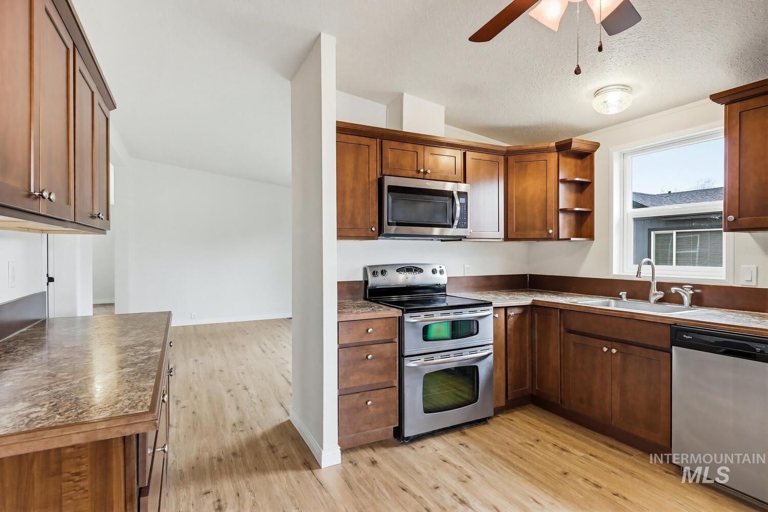 162 1st Street North Marsing, ID 83639 - Photo 12 of 39 Kitchen with stainless steel appliances, ceiling fan, light wood-style flooring, open shelves, and wood finish cabinets