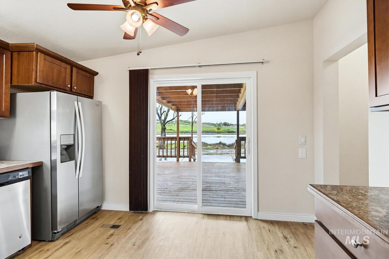 162 1st Street North Marsing, ID 83639 - Photo 13 of 39 Kitchen with stainless steel dishwasher, a ceiling fan, light wood-type flooring, a water view, and light countertops