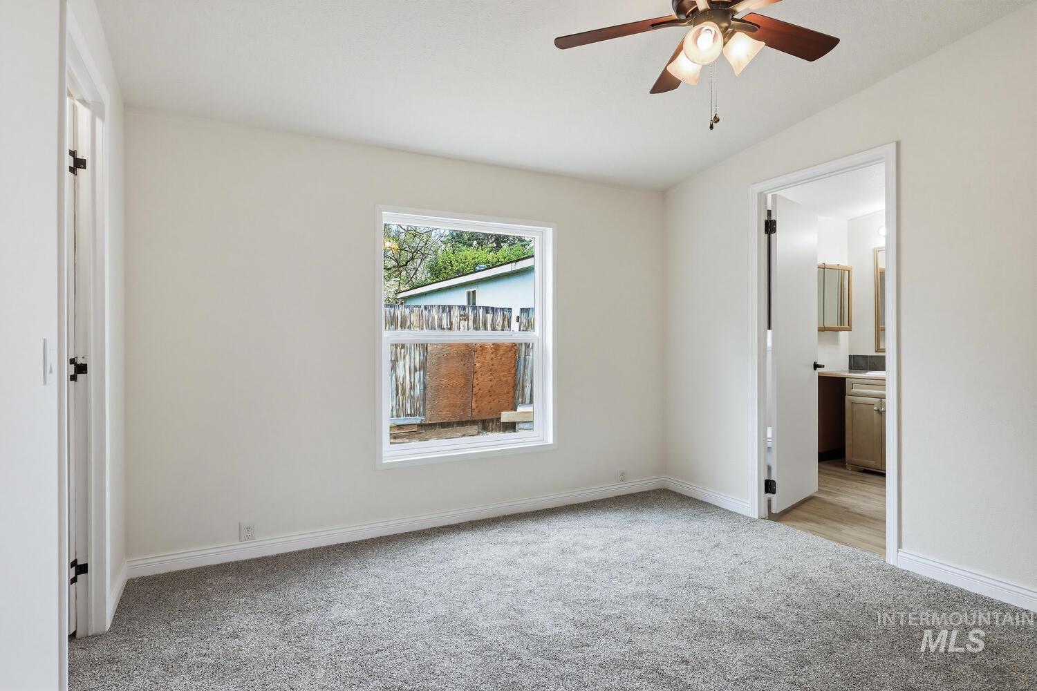 162 1st Street North Marsing, ID 83639 - Photo 15 of 39 Unfurnished bedroom featuring light colored carpet, a ceiling fan, and connected bathroom
