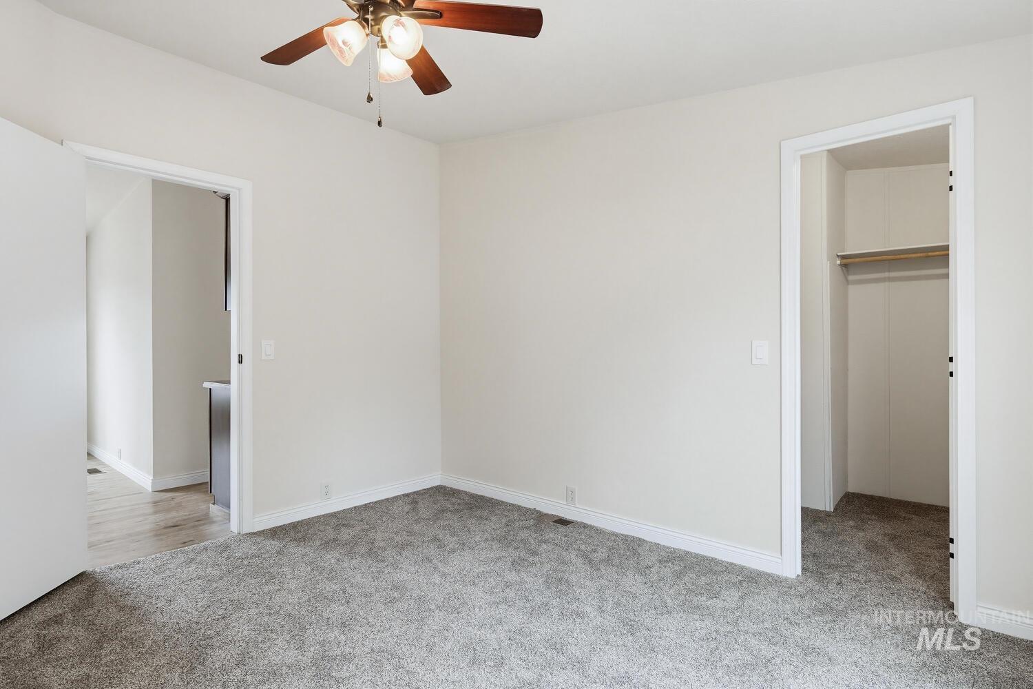 162 1st Street North Marsing, ID 83639 - Photo 16 of 39 Unfurnished bedroom with light colored carpet, a walk in closet, and a ceiling fan