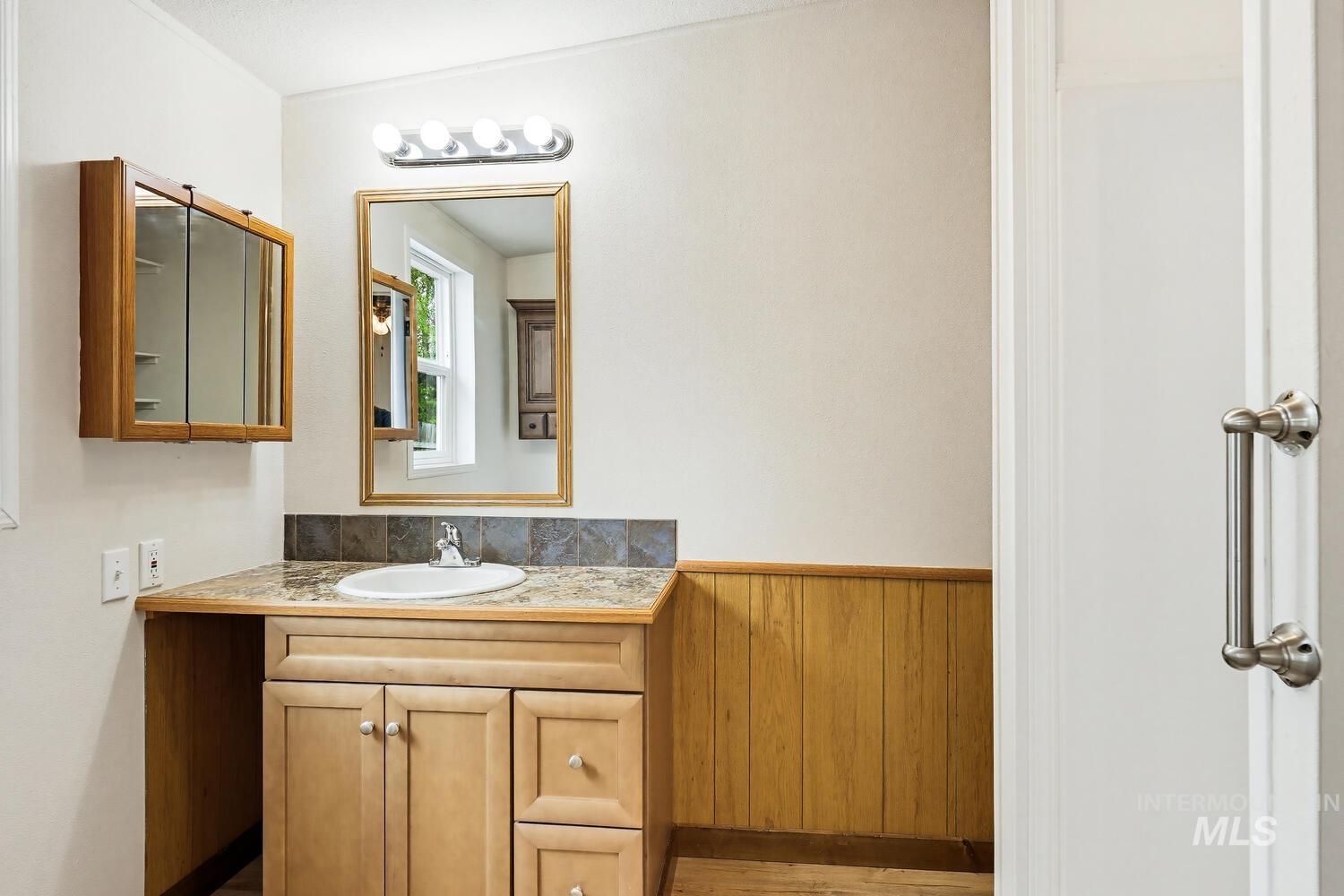 162 1st Street North Marsing, ID 83639 - Photo 18 of 39 Bathroom featuring vanity, a wainscoted wall, and wood walls