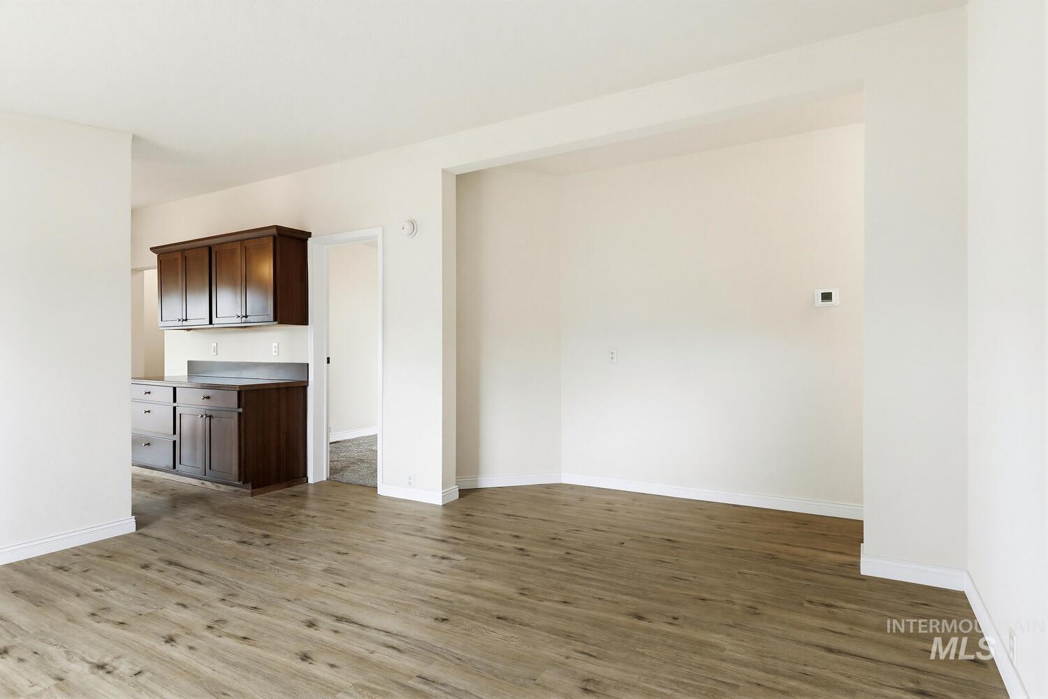 162 1st Street North Marsing, ID 83639 - Photo 6 of 39 Unfurnished living room with dark wood-style flooring and baseboards
