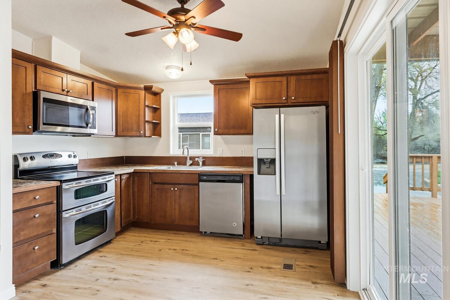 162 1st Street North Marsing, ID 83639 - Photo 10 of 39 Kitchen featuring stainless steel appliances, ceiling fan, open shelves, light wood-style flooring, and lofted ceiling