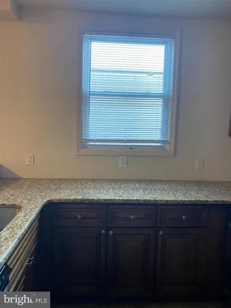 a kitchen with granite countertop a stove top oven microwave and cabinets