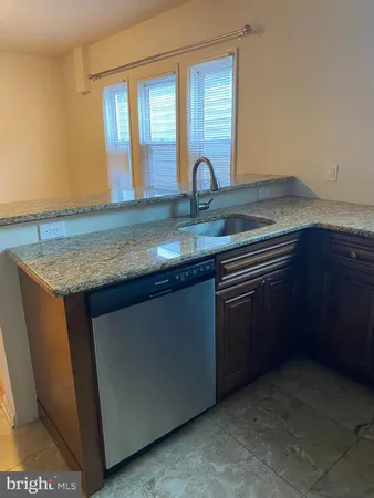 a kitchen with granite countertop cabinets sink and window