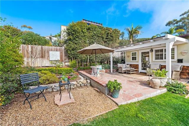 a view of a patio with chairs and table and chairs under an umbrella