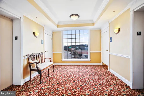 a view of a hallway with furniture and a window