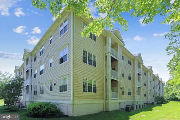 a large building with a small yard and a large tree