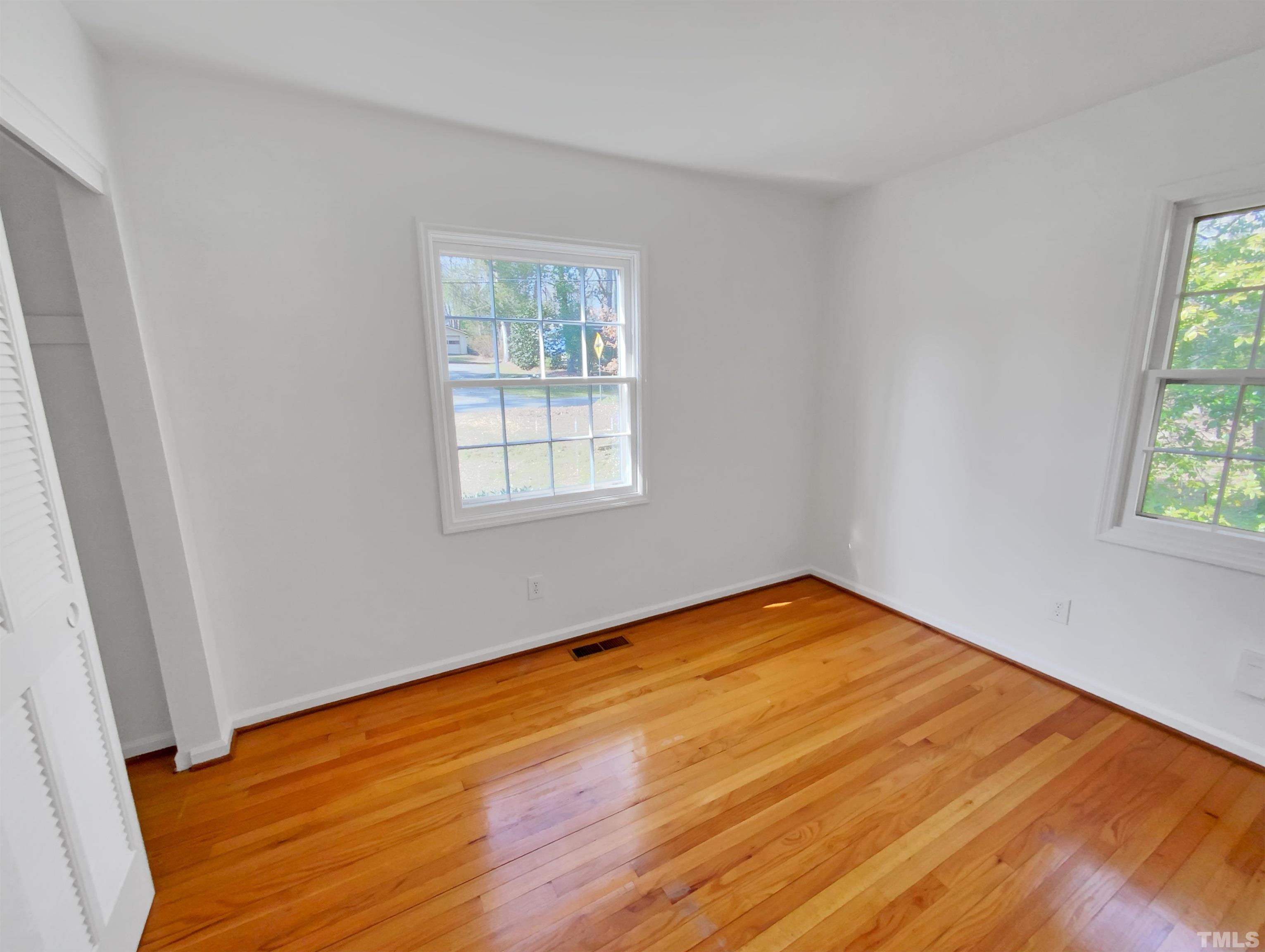 1618 Medfield Road Raleigh, NC 27607 - Photo 14 of 22 an empty room with wooden floor and windows