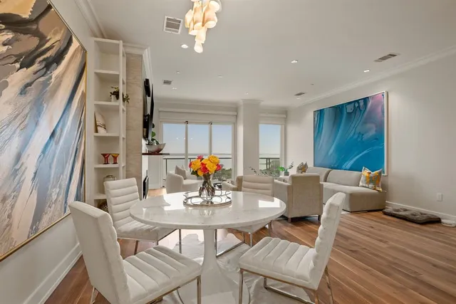 a view of a dining room with furniture a chandelier and wooden floor