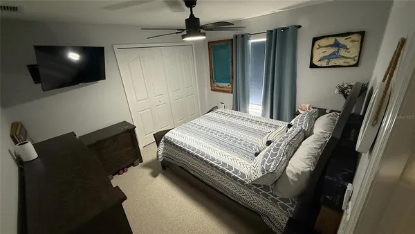 a bedroom with a bed and a flat screen tv