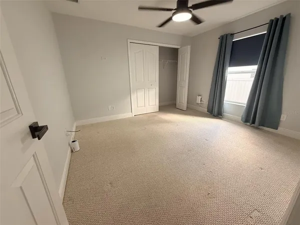 a view of a livingroom with a ceiling fan and window