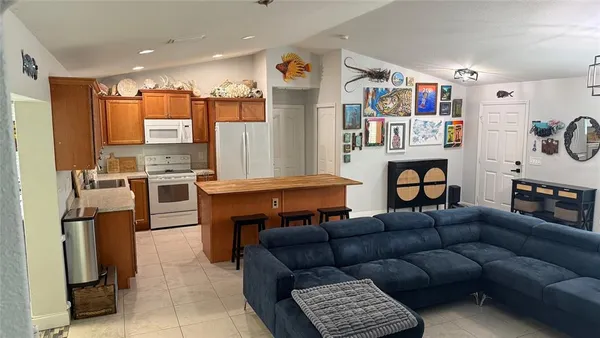 a living room with furniture kitchen view and a window