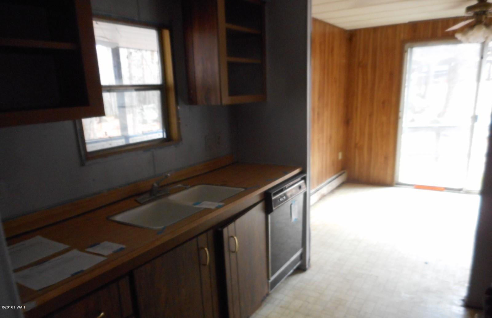 544 Hummingbird Lane Hawley, PA 18428 - Photo 11 of 16 a kitchen with a sink a window and a potted plant