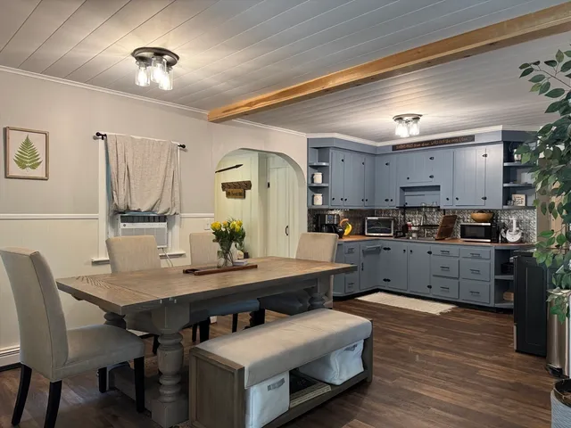 a kitchen with granite countertop a table chairs sink and cabinets