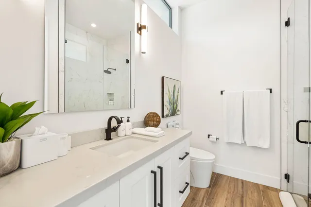 a bathroom with a double vanity sink mirror and toilet