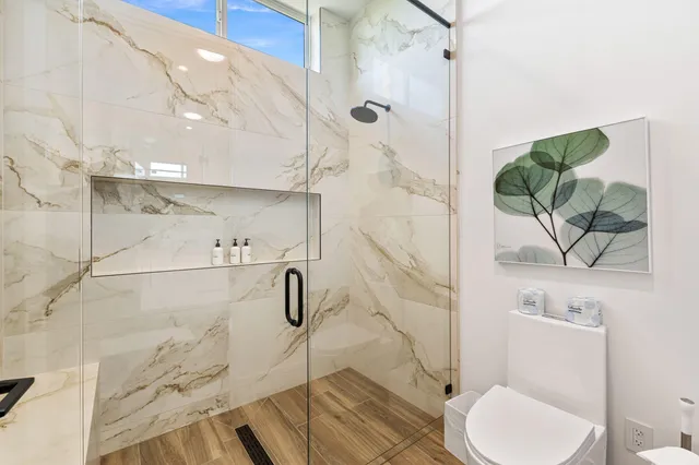 a bathroom with a toilet and a shower