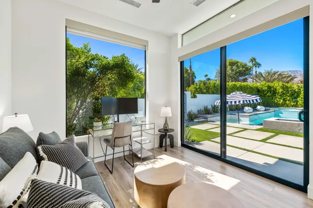 a living room with furniture and a floor to ceiling window