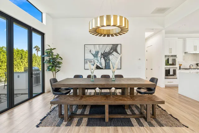 a view of a dining room with furniture a chandelier and wooden floor