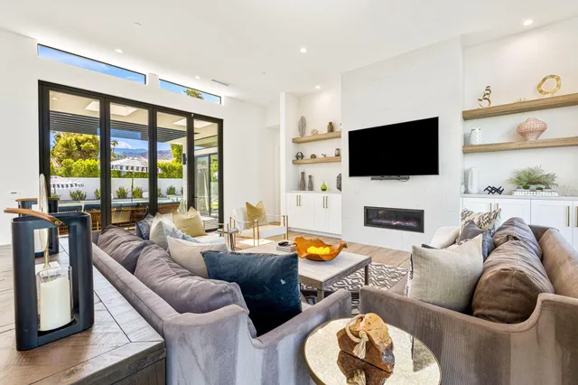 a living room with fireplace a flat screen tv and a large window
