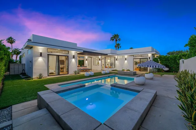 a view of a house with swimming pool and sitting area