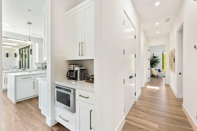 a kitchen with white cabinets and white appliances