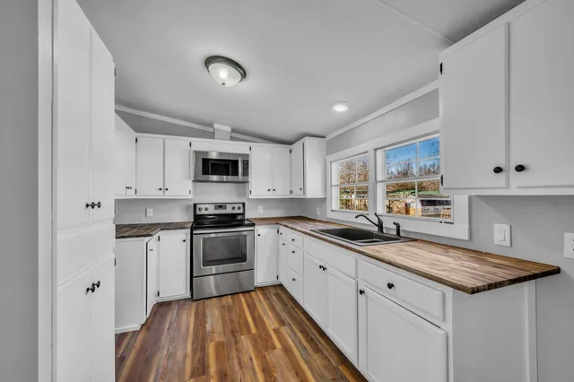 a kitchen with granite countertop a sink stainless steel appliances and cabinets