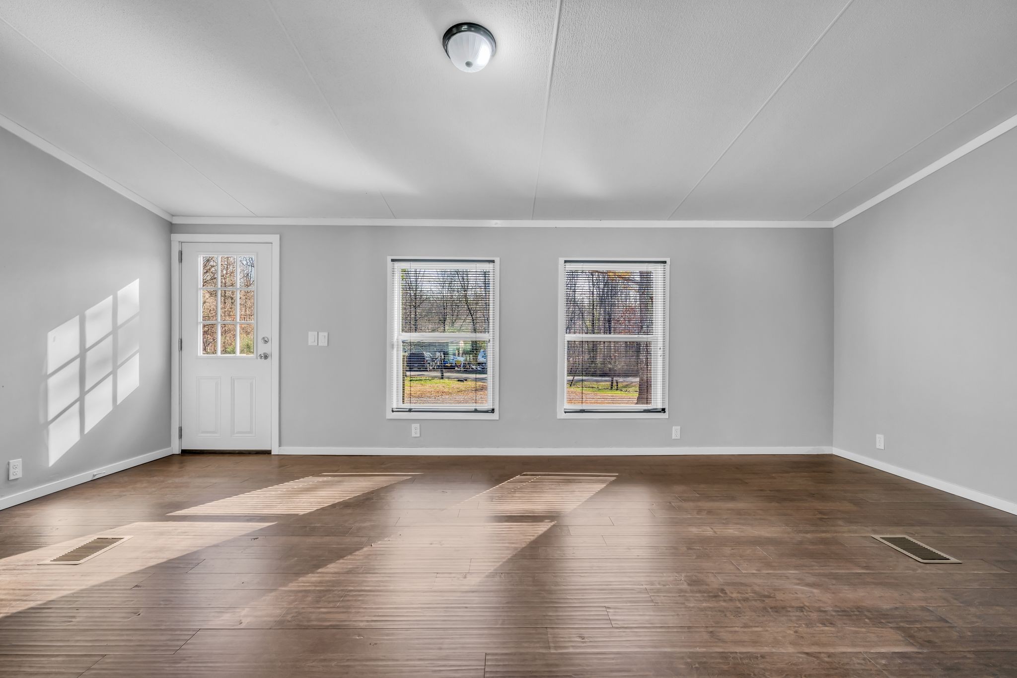 2335 Wayne Road Bon Aqua, TN 37025 - Photo 5 of 30 an empty room with wooden floor and windows
