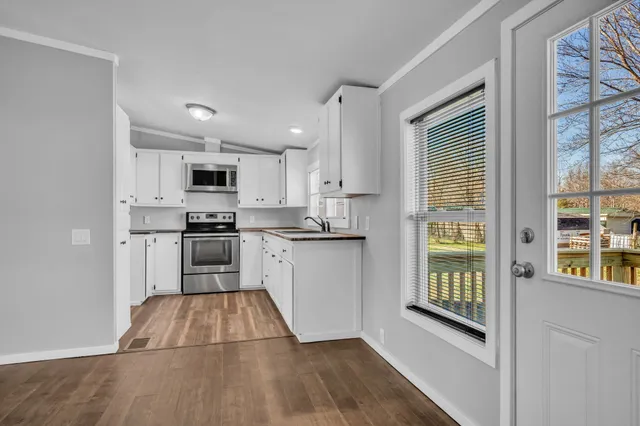 a kitchen with granite countertop a refrigerator and a stove top oven