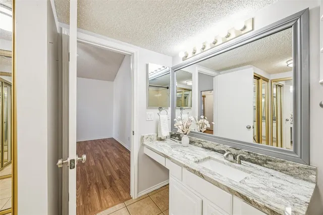 a bathroom with a granite countertop sink and a mirror