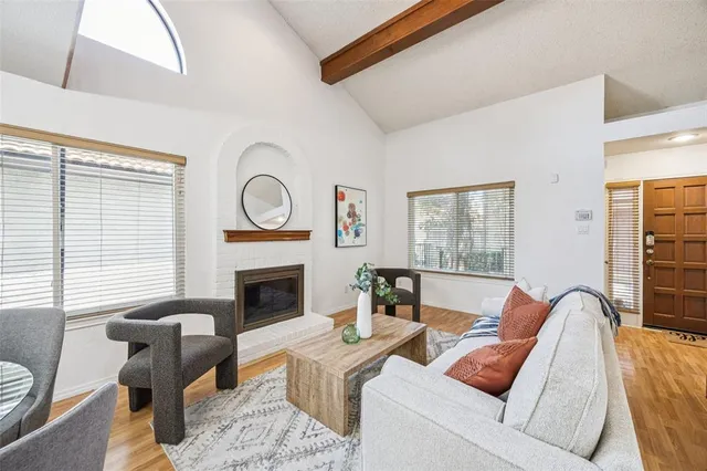 a living room with furniture a fireplace and a large window