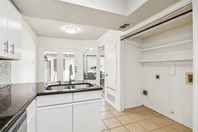 a kitchen with a refrigerator and white cabinets