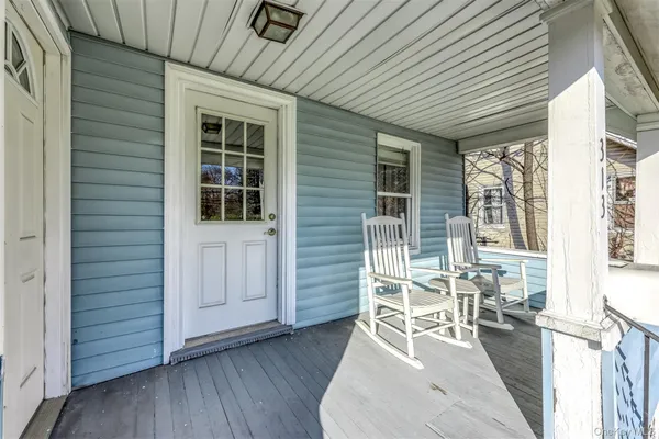 a patio with table and chairs and wooden floor