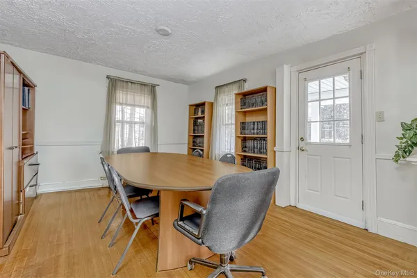 a view of a a dining room with furniture window and wooden floor