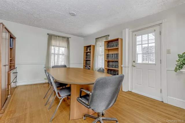 a view of a a dining room with furniture window and wooden floor