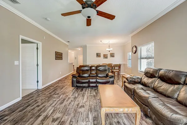 a living room with furniture and a wooden floor
