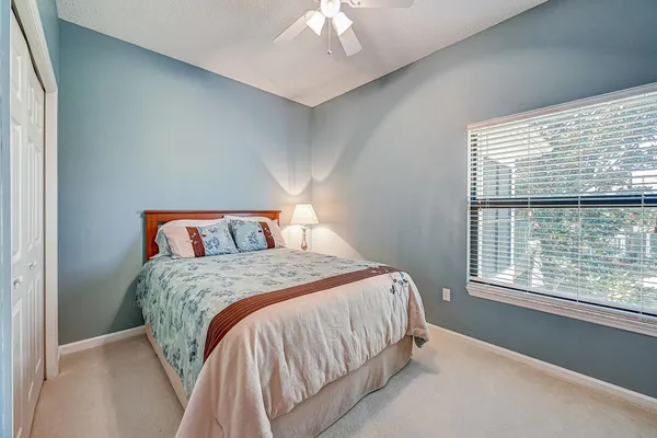 a bedroom with a bed and a large window