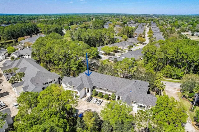 a view of a white house with a large space next to a road